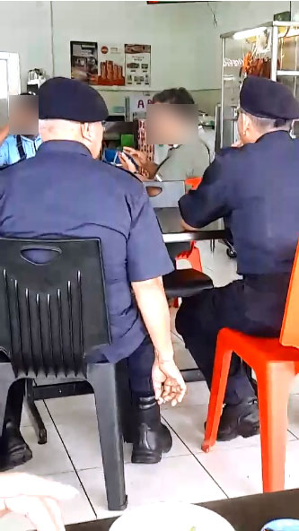 警员无视禁烟令，公然在餐馆内吸烟。