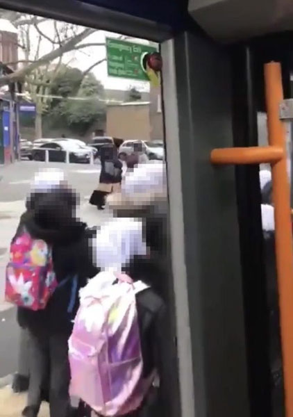 男子在女校外下车，在镜头后喃喃自语，对这些女生发表种族歧视的言论。