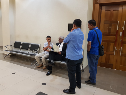 莫哈末阿兹利（左坐者）闻判后，与律师T.慕拉拉祖在庭外讨论上诉细节。