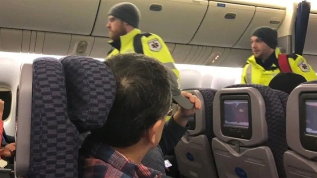 救护人员将身体不适的乘客接下飞机。