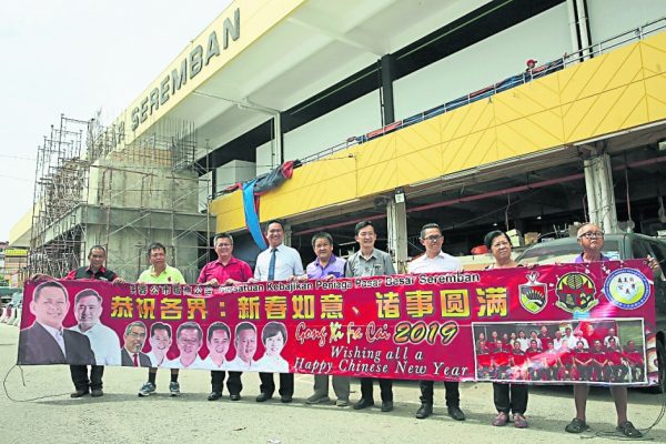 吴金财（左3起）、张聒翔、许礼叠、谢琪清、何永铧及芙蓉公市贩商公会理事拿起贺年横幅向各界拜年。