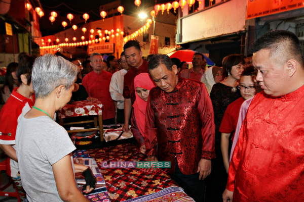 阿米努丁（右2）在吴金财（右起）、夫人拿汀斯里旺哈丝妮、张聒翔、叶朝政和叶耀荣陪同下，一起巡视“2019年诸事旺新春嘉年华”的摊位。