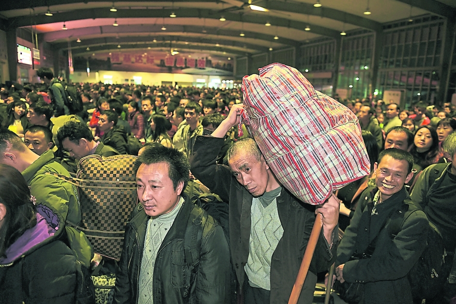 2019年春运周一开始，图为周日晚上在深圳西站，乘客扛上行李准备上车。（新华社）