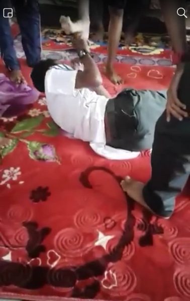 一名中学生卧倒在地面，被霸凌者拳打脚踢。