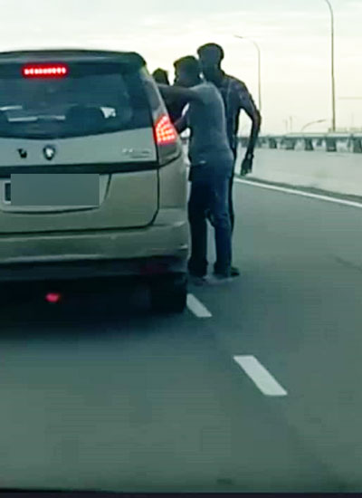 3名男子在吉里望桥截停一辆休旅车，并挥拳殴打车内的司机。（图取自互联网）
