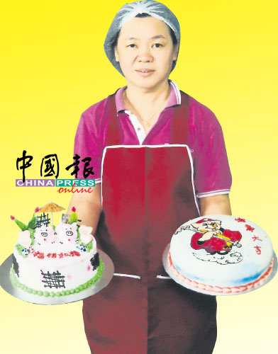 蔡玉燕捧着“诸事大吉及“福相如猪”2款猪年蛋糕贺新岁。