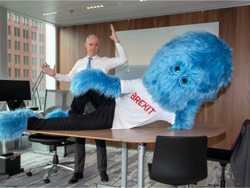 荷兰政府把脱欧设计成一只蓝色大毛怪，可见外长卜洛克站在办公桌后，对身着“脱欧”字样上衣的蓝色怪兽，似乎束手无策。