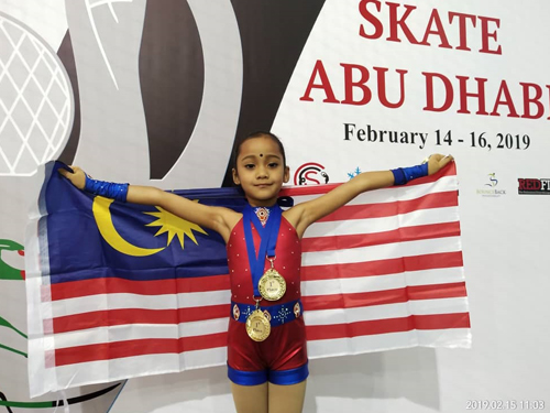 丝丽骄傲的拿着国旗，和周五赢得的两面金牌合影。