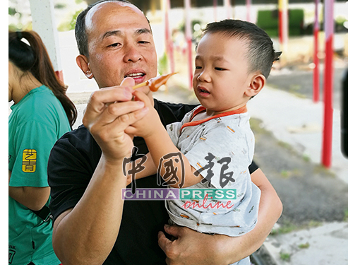 吃年糕快高长大！吴亚海趁着过农历新年，灌输孩子中国传统文化习俗。