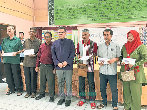 赛夫丁（左4）移交支票给火灾灾民，左3是甘榜爪哇乡委会主席阿布卡欣。