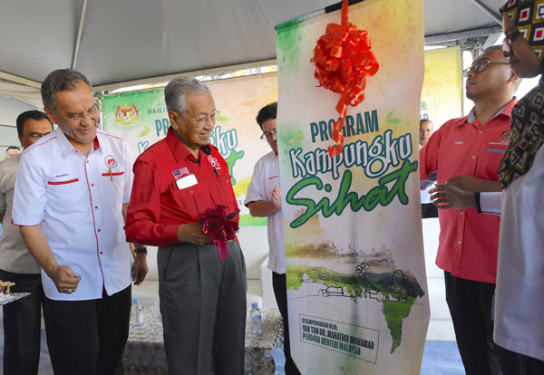 首相敦马哈迪（左2）周日回选区主持“我的健康甘榜”活动推介礼。左为卫长拿督斯里祖基菲里。（马新社）