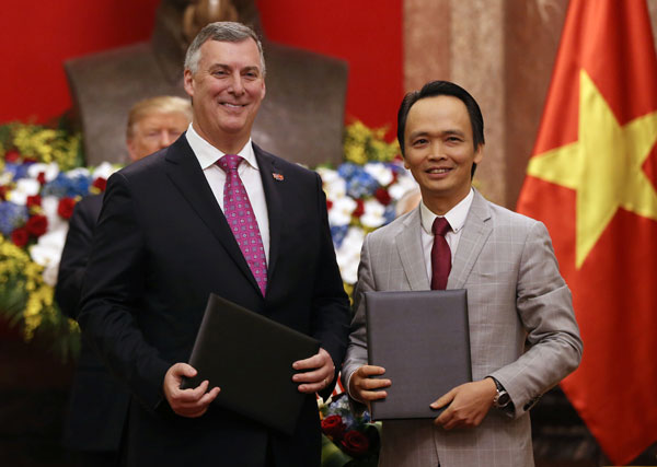 美国总统特朗普（后左）与越南国家主席阮富仲（后右）见证下，波音总执行长迈卡利斯特（左）和越捷航空总执行长阮氏芳邵交换合约文件。（法新社）