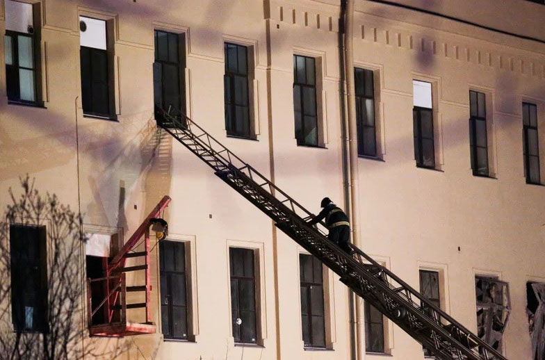 消防员登上云梯进入建筑。