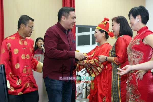 会场进行三大民族传统服装表演，陆兆福（左2）派发红包予参与者，左1为陈永明。