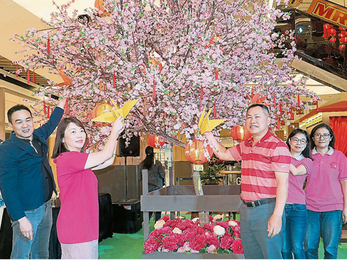 李明明（左起）、黄洁莹、王绥生、萧美娟和陈炎镁把纸鹤挂上梅花树，为癌友们献上祝福。