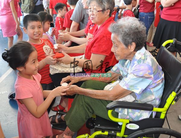 外曾孙女向92岁外曾祖母陈玉金（右）敬茶，祝愿外曾祖母身体健康，场面非常温馨。