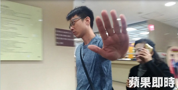 张枢亚出庭后阻挡记者拍摄。