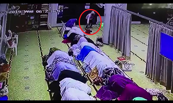 窃贼（红圈处）趁女穆斯林跪拜祈祷时，速抢走其中1人的手提袋。