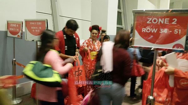 宾雅敏（左2）于周四晚，亲自在第2吉隆坡国际机场派发礼袋给首航搭客。