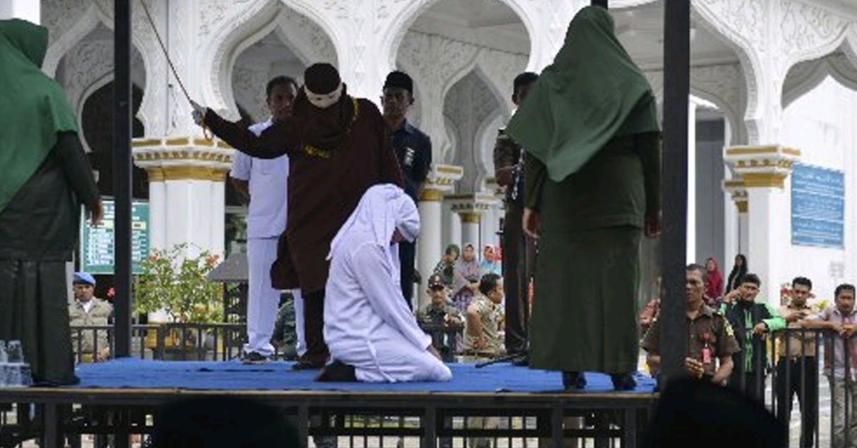 女嫌犯跪坐在地接受鞭刑。（法新社）