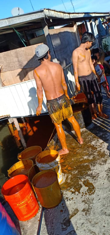 油棕公司员工和当地居民以人手方式，第一时间用桶把海面的棕油盛捞起来。