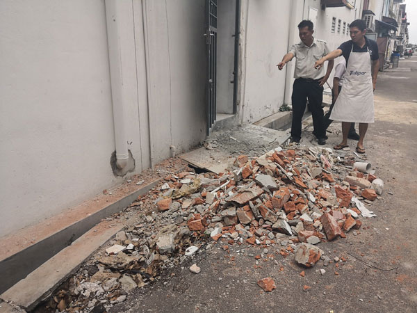 刘学礼（右起）向叶贵宏投诉被丢弃后巷的建筑材料。