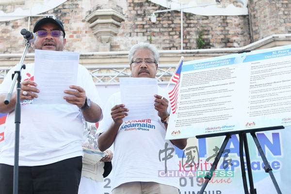 慕查希（左）代表政府宣读2019年吉隆坡和平宣言，瓦塔慕迪（右）在旁见证。