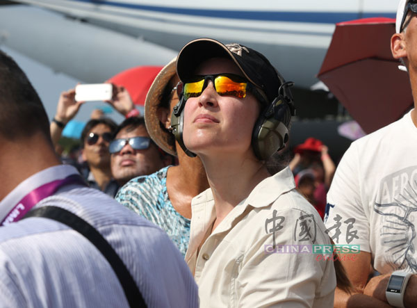 民众套上头戴式耳机，进入机场坪上观赏精彩绝伦的特技飞行表演。