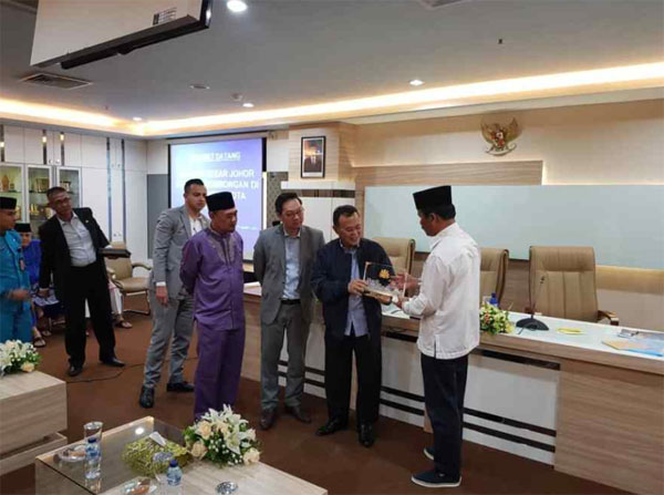 印尼峇淡岛市长莫哈末鲁迪（右）赠送纪念品给奥斯曼，由潘伟斯（左2）陪同。