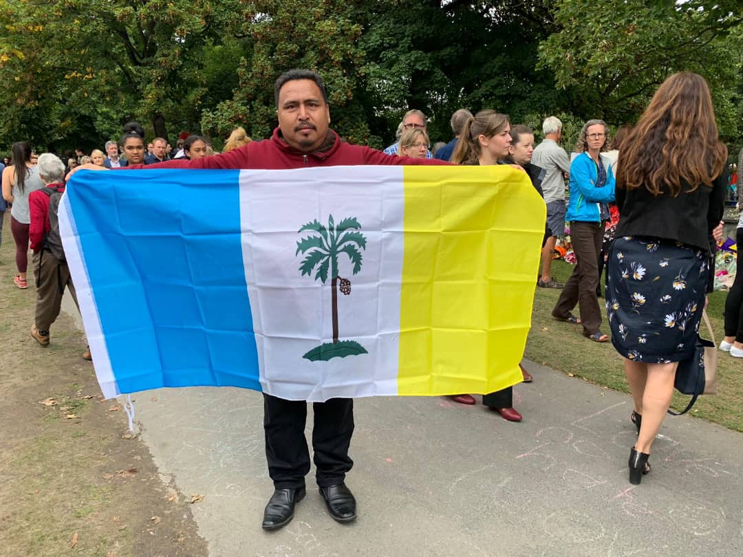 阿兹鲁手持槟州州旗，到基督城植物园悼念遇害民众，也示支持。