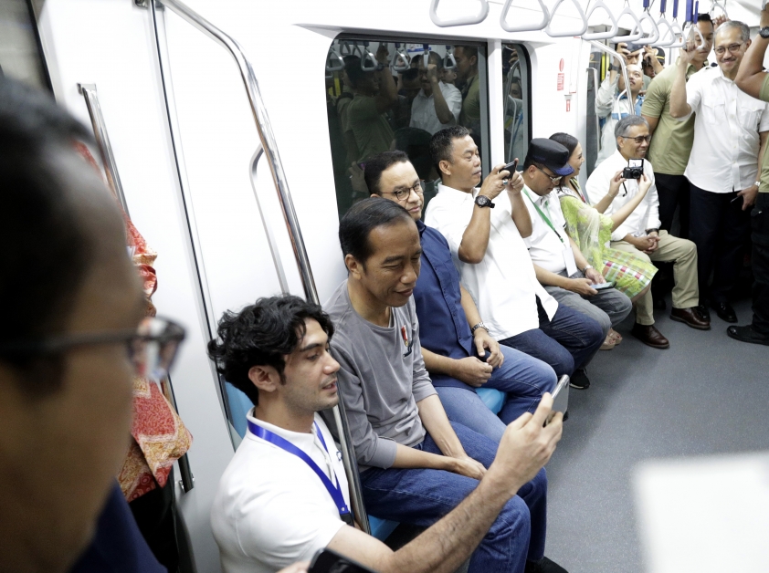 印尼总统佐科威（中）周日乘坐耶加达地铁，在车厢里与印尼影星拉迪安自拍。