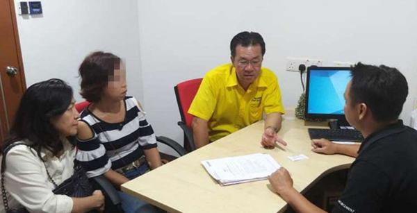 叶耀星及许碧珠（左1及左3）陪同受害者（左2）向公司委员会官员投诉。