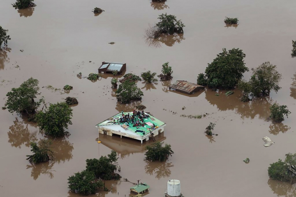 洪水摧毁贝拉多条村庄，灾民爬到屋顶上等待救援。（法新社）