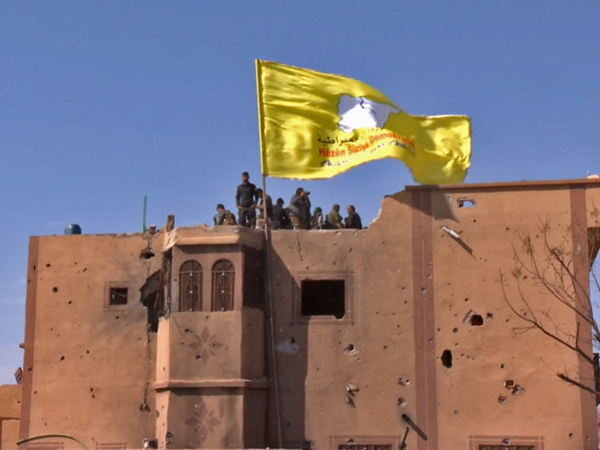 IS被彻底瓦解后，SDF军人在叙利亚巴古兹村升起该组织的黄旗。