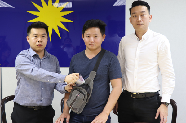 刘国南（左起）和王春民在袁展豪陪同下，示范有关警员，如何从其斜肩包取走里面的现金。