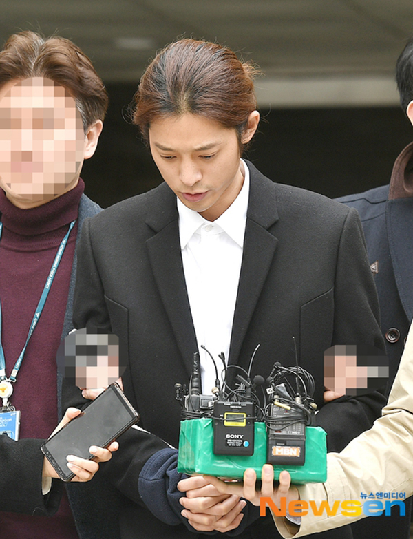 郑俊英经过3小时审问，双手被绑警绳走出法院。