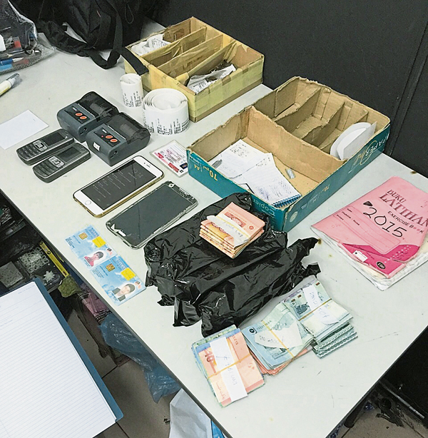警方搜获“跑腿”收取非法万字的手机、纪录薄及现金等。