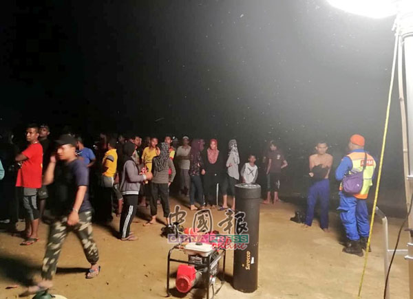 消拯员在河边设立救援行动中心，在场还有等待消息的村民。