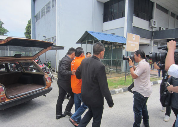 嫌犯（右2）被押抵法庭后，各媒体竞相猎取其面貌。