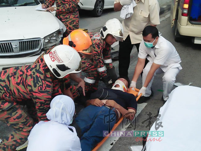 消拯员和医务人员将重伤者抬上担架，准备送院治疗。