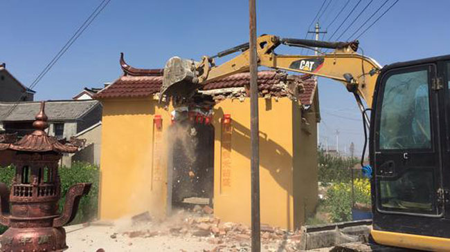 当局出动挖掘机拆毁土地公庙。