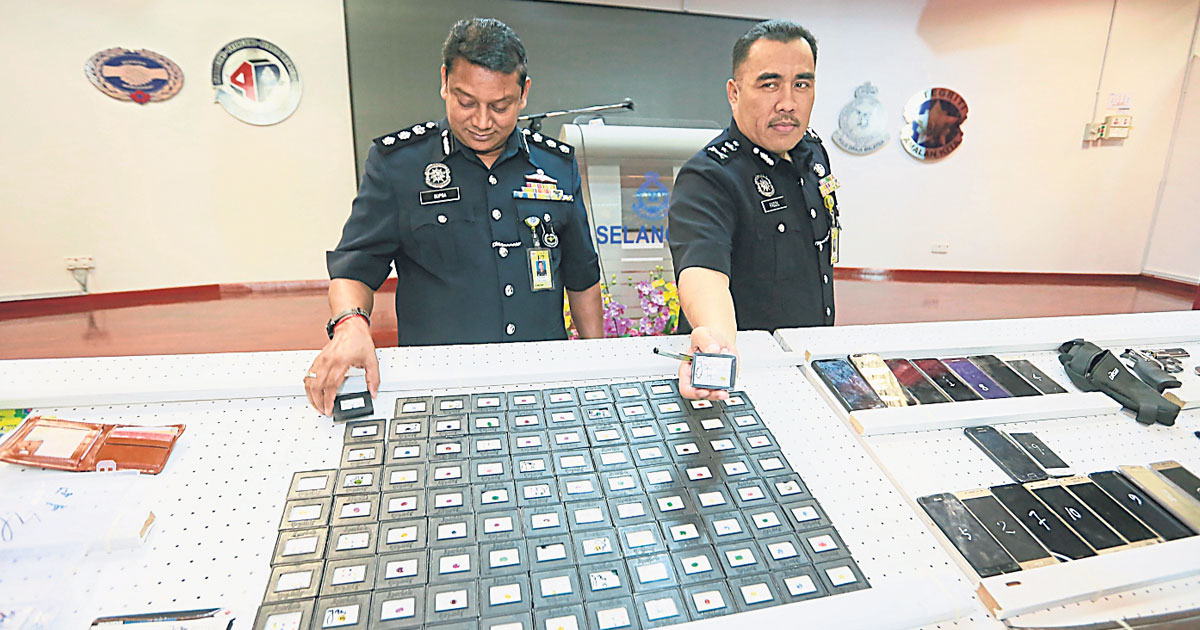 法迪尔（右）和副手苏柏马廉展示警方起获市价10万令吉的160枚宝石。