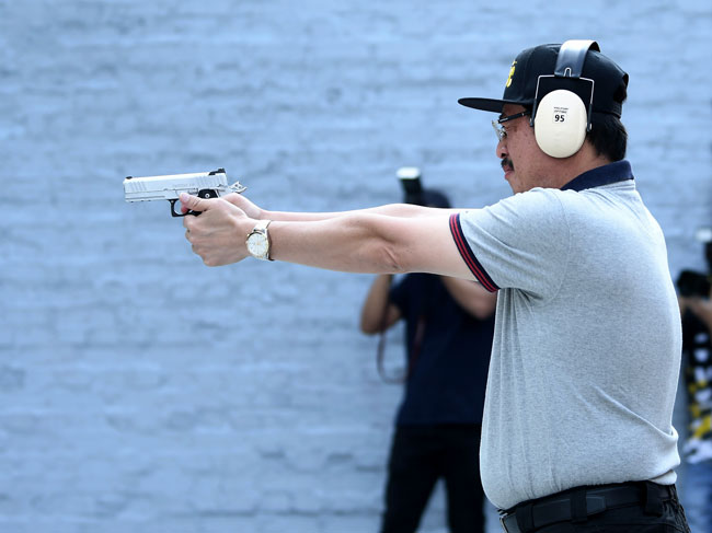 阿占峇基在主持射击比赛开幕仪式时，不忘展现他的枪法。