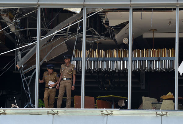 香格里拉酒店的玻璃窗被震飞，电线自天花板向下垂。警方抵达现场展开调查。（法新社）