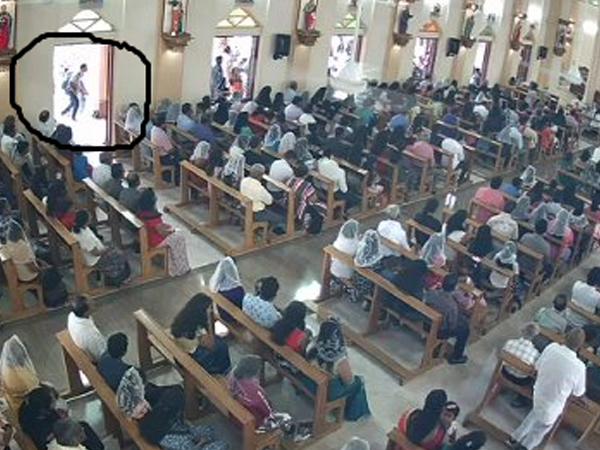 闭路电视画面显示，圣巴斯提安教堂的信徒周日在做礼拜时，背着背包的炸弹客（黑圈示）埋伏在教堂外准备发动爆炸袭击。（法新社）