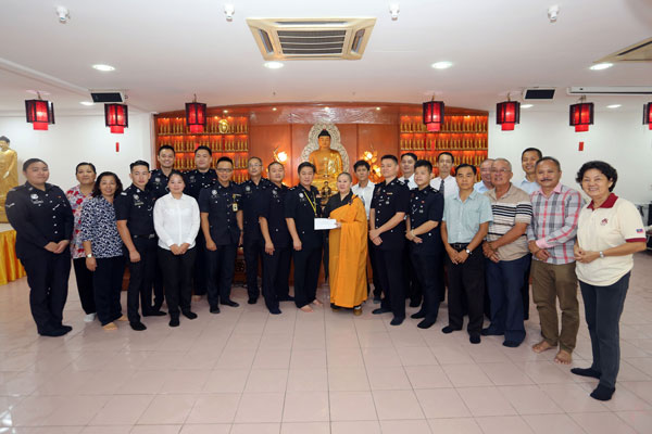 彭靖涞（前排左8）移交捐款给如尚法师（前排左9），并与各警官、警员及职员。