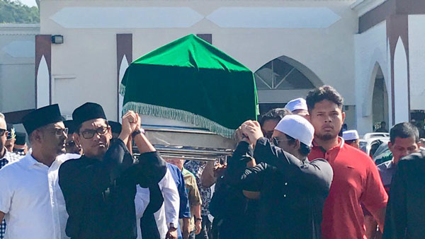 阿末法依扎（左2）为母亲扶灵，移送至甘榜甲巴央清真寺附近的马来坟场下葬。