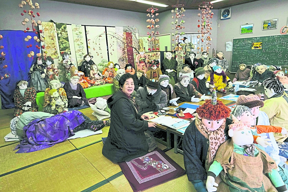 今年3月，绫野月见在名顷村接受访问，她身边坐着一群布偶，全出自她的巧手。（法新社）