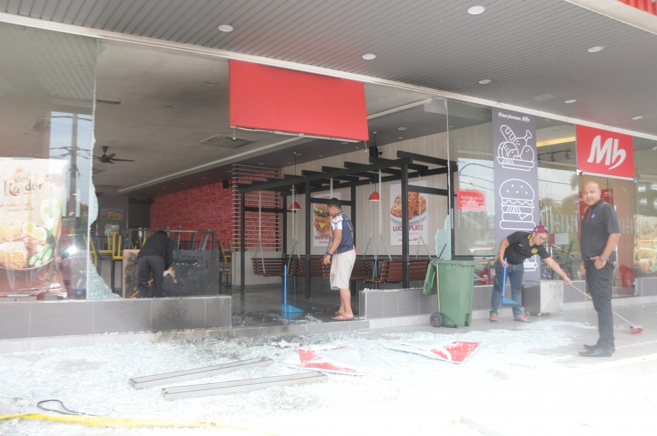 快餐店职员清理地上玻璃碎片。