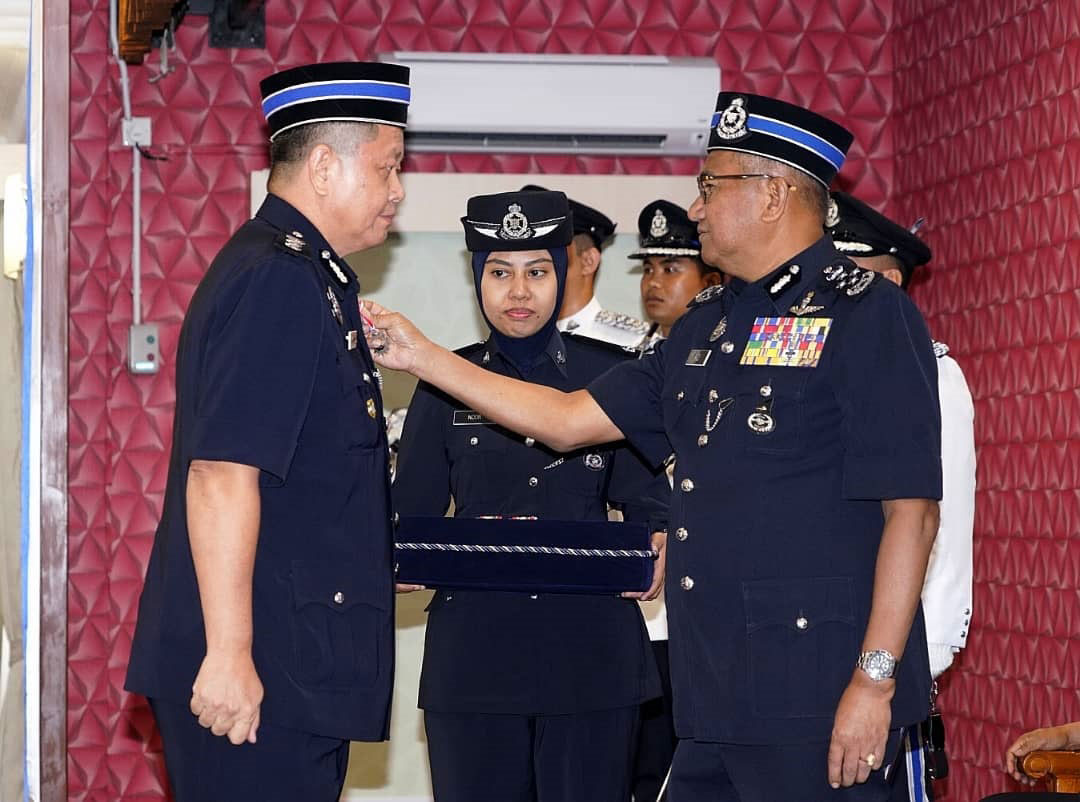 弗兹（右）颁发PJPN勋章给霹雳州警察总部防范罪案及社区安全组副主任（社区安全）黄光顺助理总监（左）。